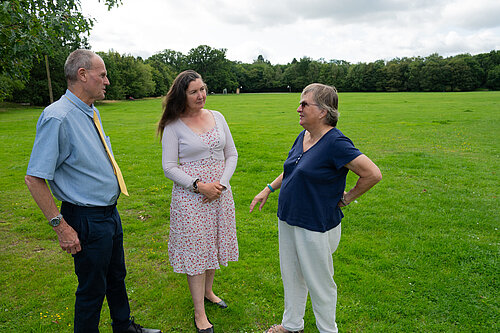 Prue and Paul talking to a resident in a green field