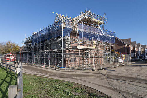 house being built covered in scaffolding 