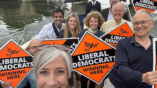 Clive Jones, Daisy Cooper and others on a boat with Lib Dem signs