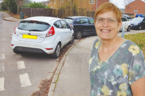 Rachelle by a corner blocked with parked cars