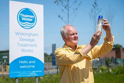 Clive Jones at the Thames Water Sewage treatment plant looking at a sample of dirty looking water