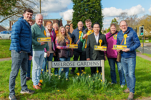 A group picture of Lib Dems by the Melrose Gardens sign in Arborfield
